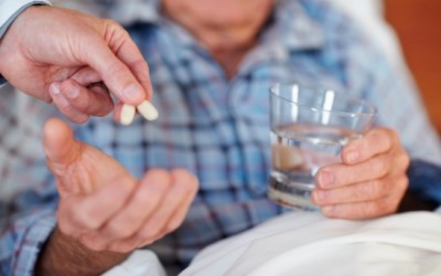 Closeup of an elderly man being given pills , focus on the medicine